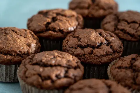 Kilka czekoladowych muffinek w papierowych papilotkach, zbliżenie.